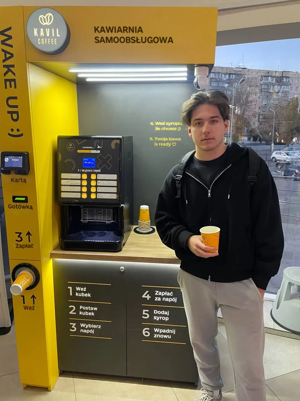 Bohdan, partner Kavil, z kawą przy swojej kawiarni samoobsługowej