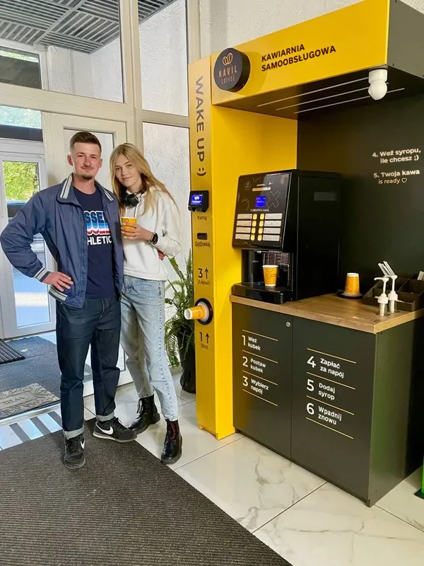 Oleksandr, partner Kavil, z kawą przy swojej kawiarni samoobsługowej