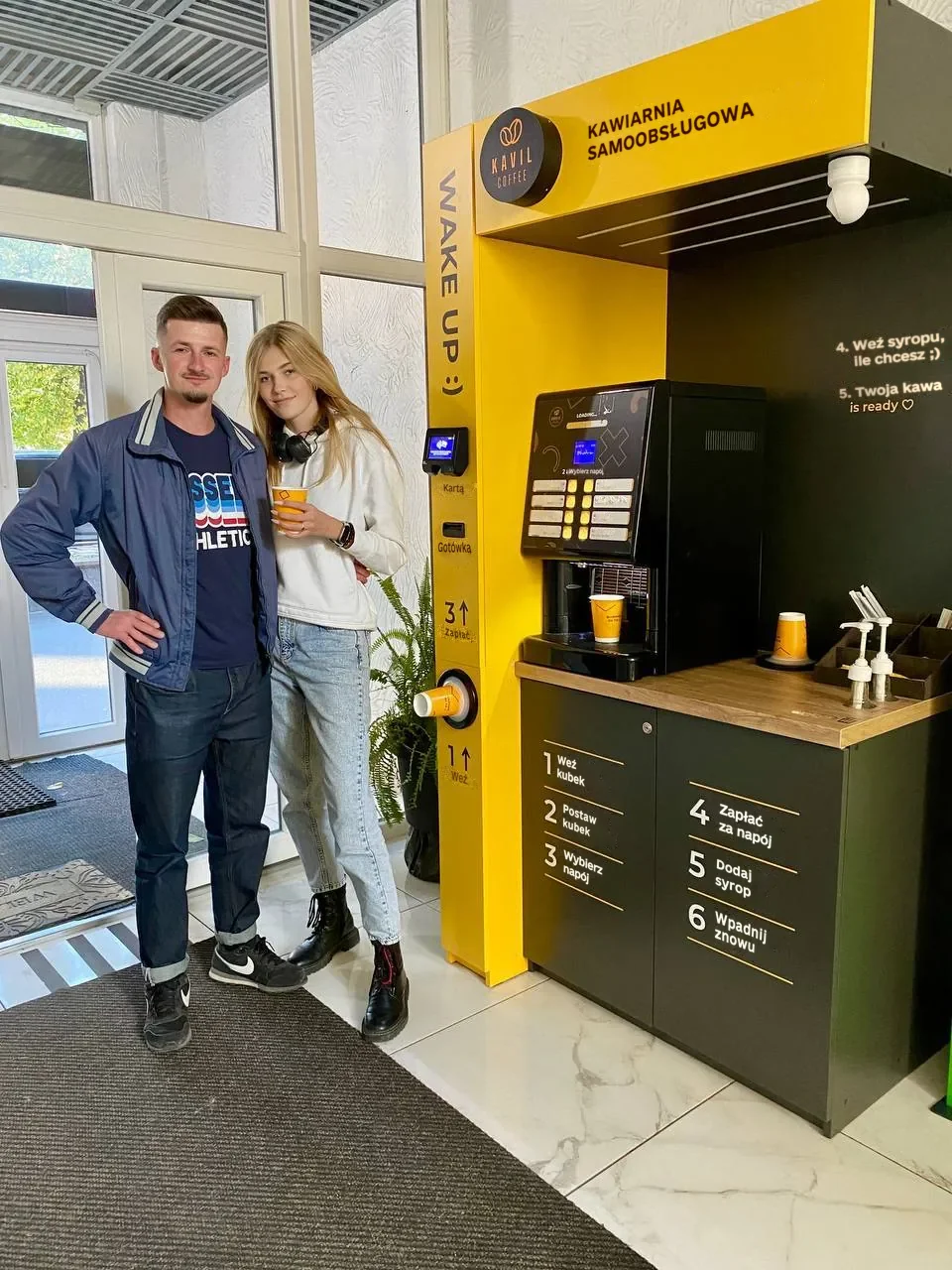 Oleksandr, partner Kavil, z kawą przy swojej kawiarni samoobsługowej