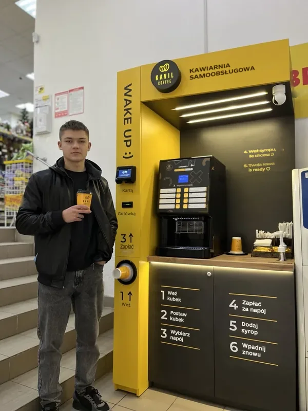 Viktor, partner Kavil, z kawą przy swojej kawiarni samoobsługowej
